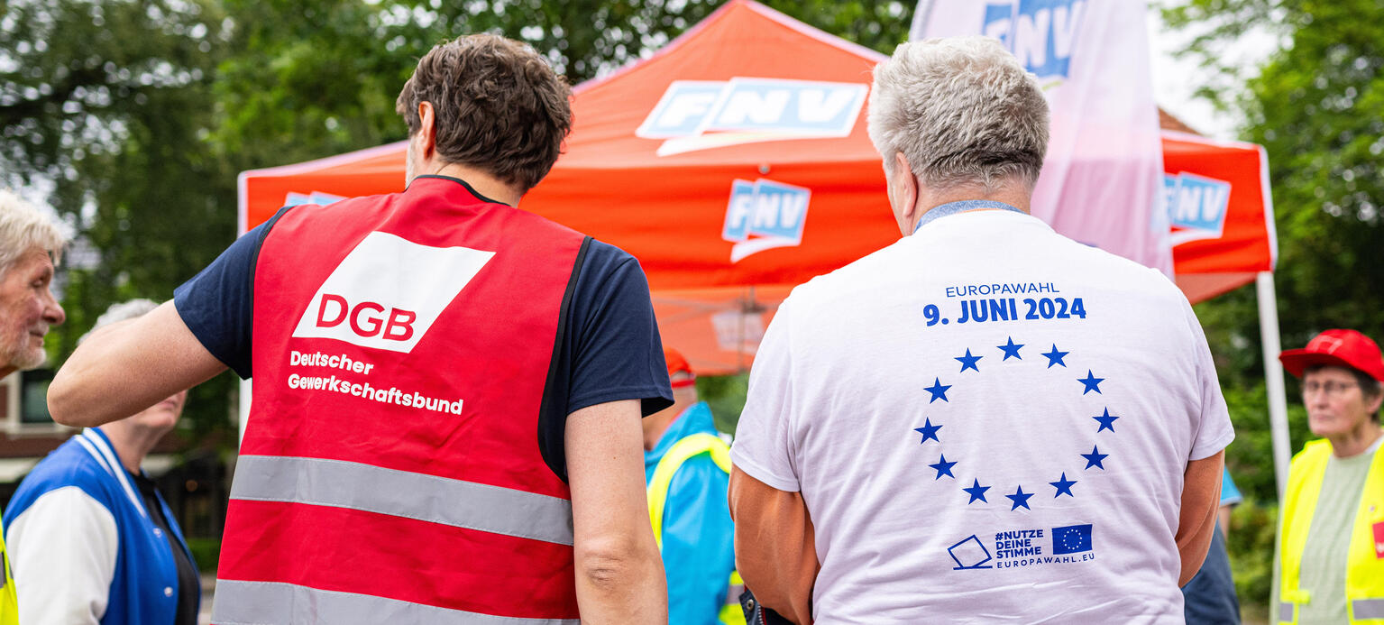 Zwei Gewerkschaftsvertreter vom DGB und CNV stehen an ihrem Infostand an der Grenze zwischen Gronau (Deutschland) und Glanerburg (Niederlande). Symbolische Grenzschließung der Gewerkschaften eine Woche vor der Europawahl. 