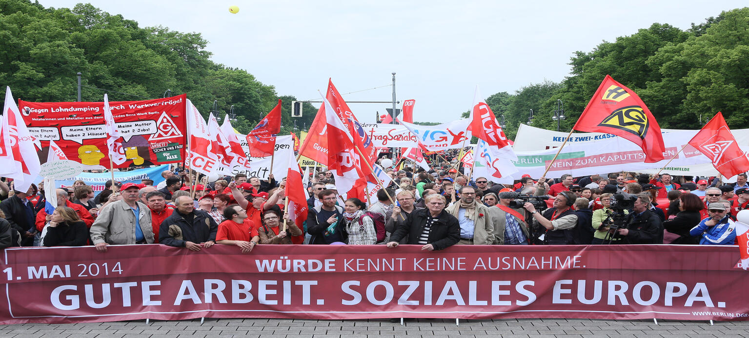 Mit Transparenten und Plakaten verfolgen Demonstranten am 01.05.2014 in Berlin die Kundgebung des Deutschen Gewerkschaftsbundes DGB zum 1. Mai. 