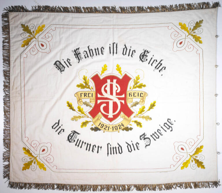 Fahne der Freien Turn- u. Sportvereinigung Rheda i. Westf, 1921, mit der Aufschrift: „Die Fahne ist die Eiche, die Turner sind die Zweige, Frei Heil, 1921-1924